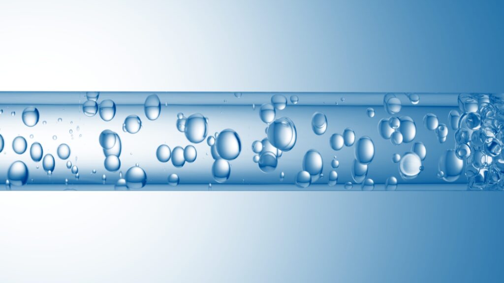 Closeup shot of horizontal glass tube with clear bubbles flowing through it